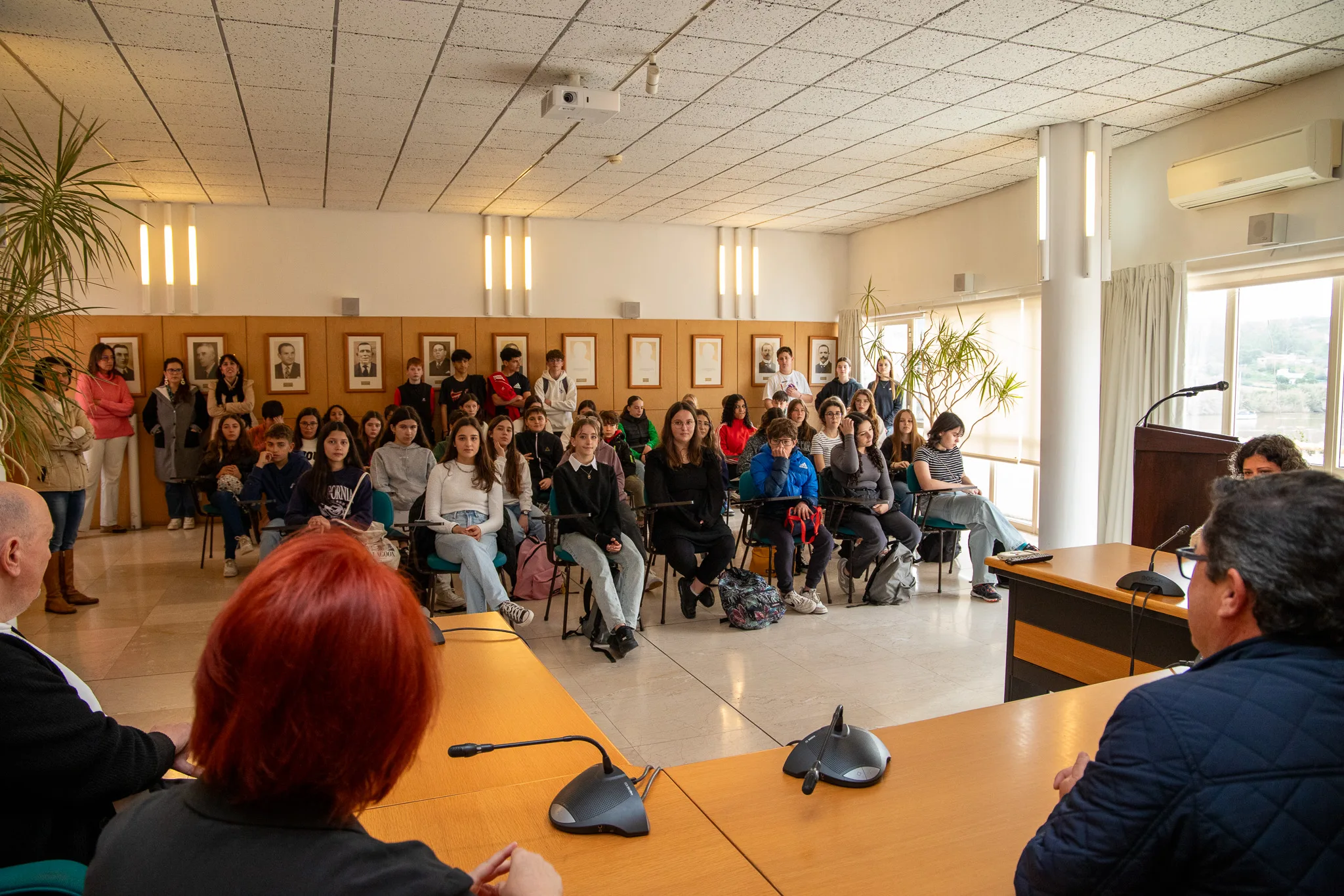 Público assistindo a palestra em sala de conferências.