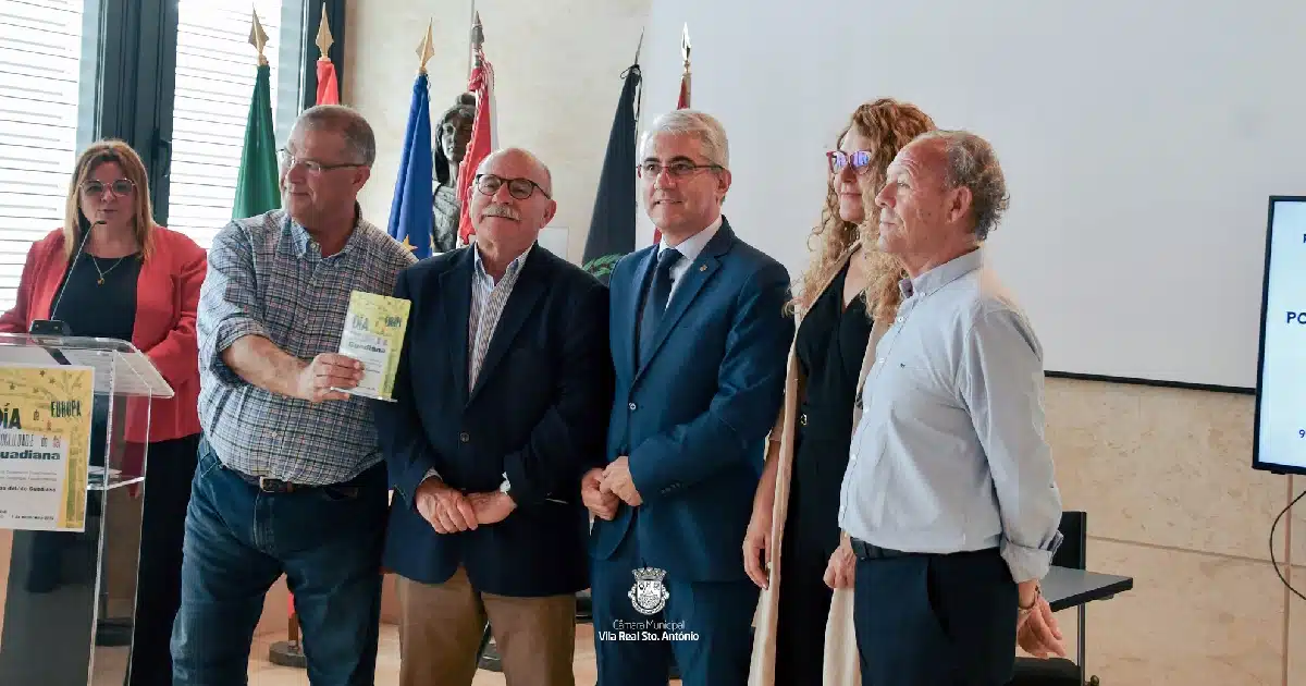 Evento em câmara com grupo segurando livro.