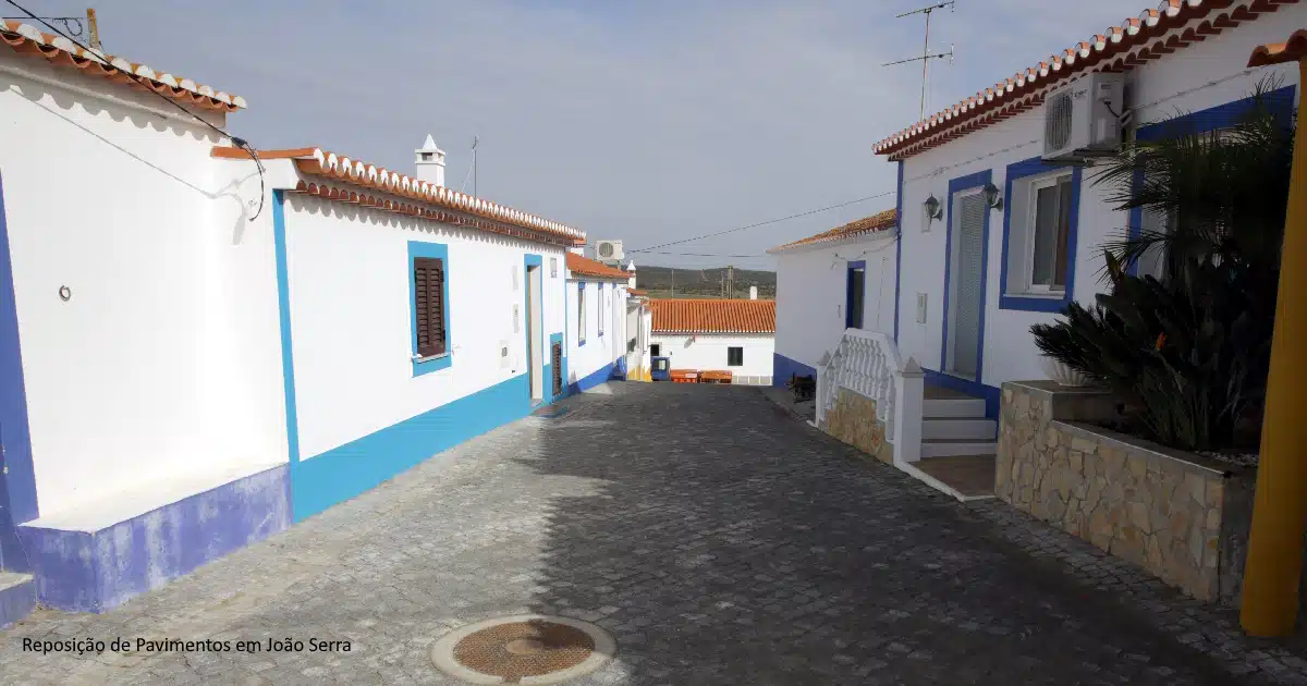 Rua tradicional portuguesa com casas brancas e azuis.